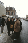 851900 Afbeelding van enkele mensen in gesprek bij de rommelmarkt op de hoek van de besneeuwde Willemstraat en ...